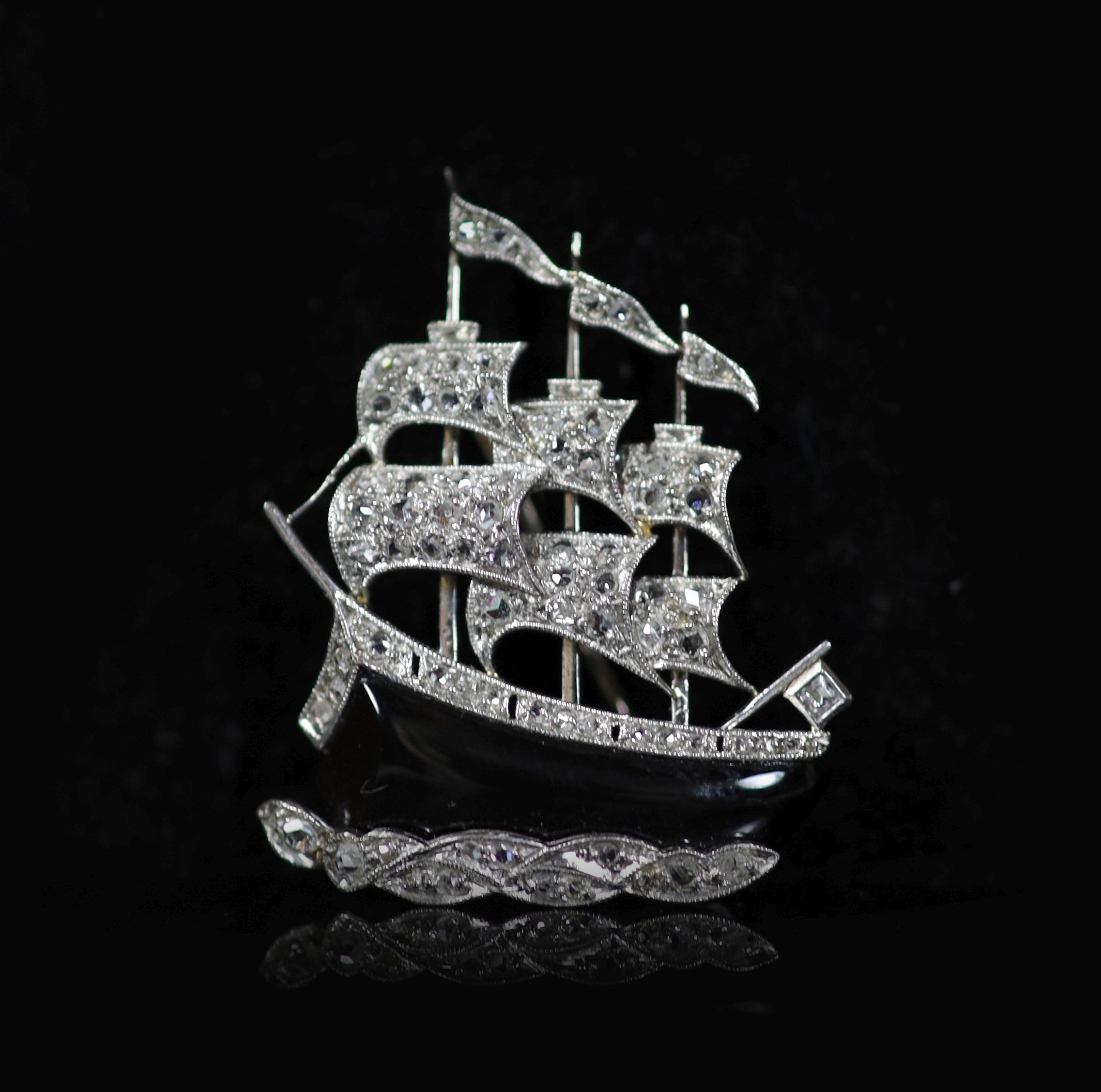 A modern white gold, black enamel and diamond chip set brooch, modelled as a three masted sailing ship